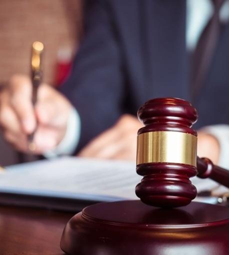 Gavel with a lawyer blurred in the background.