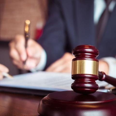 Gavel with a lawyer blurred in the background.